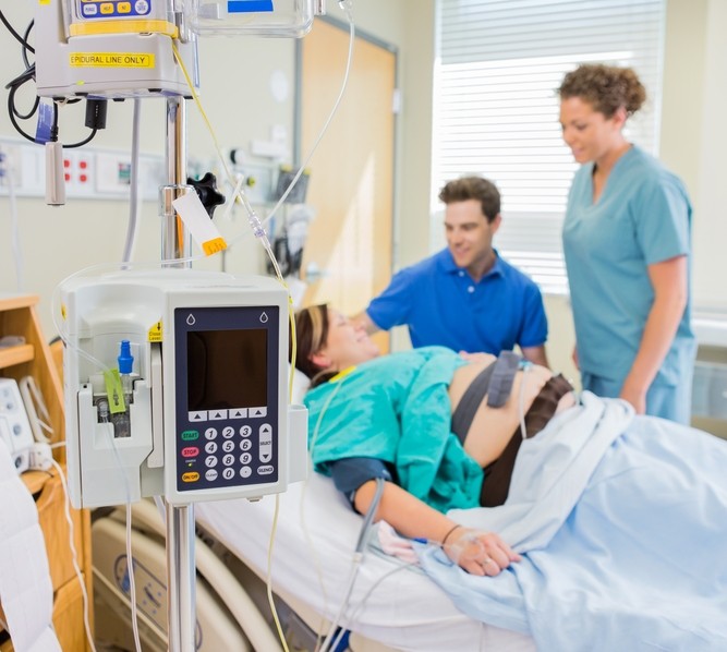 Woman in hospital bed hooked up to monitors.