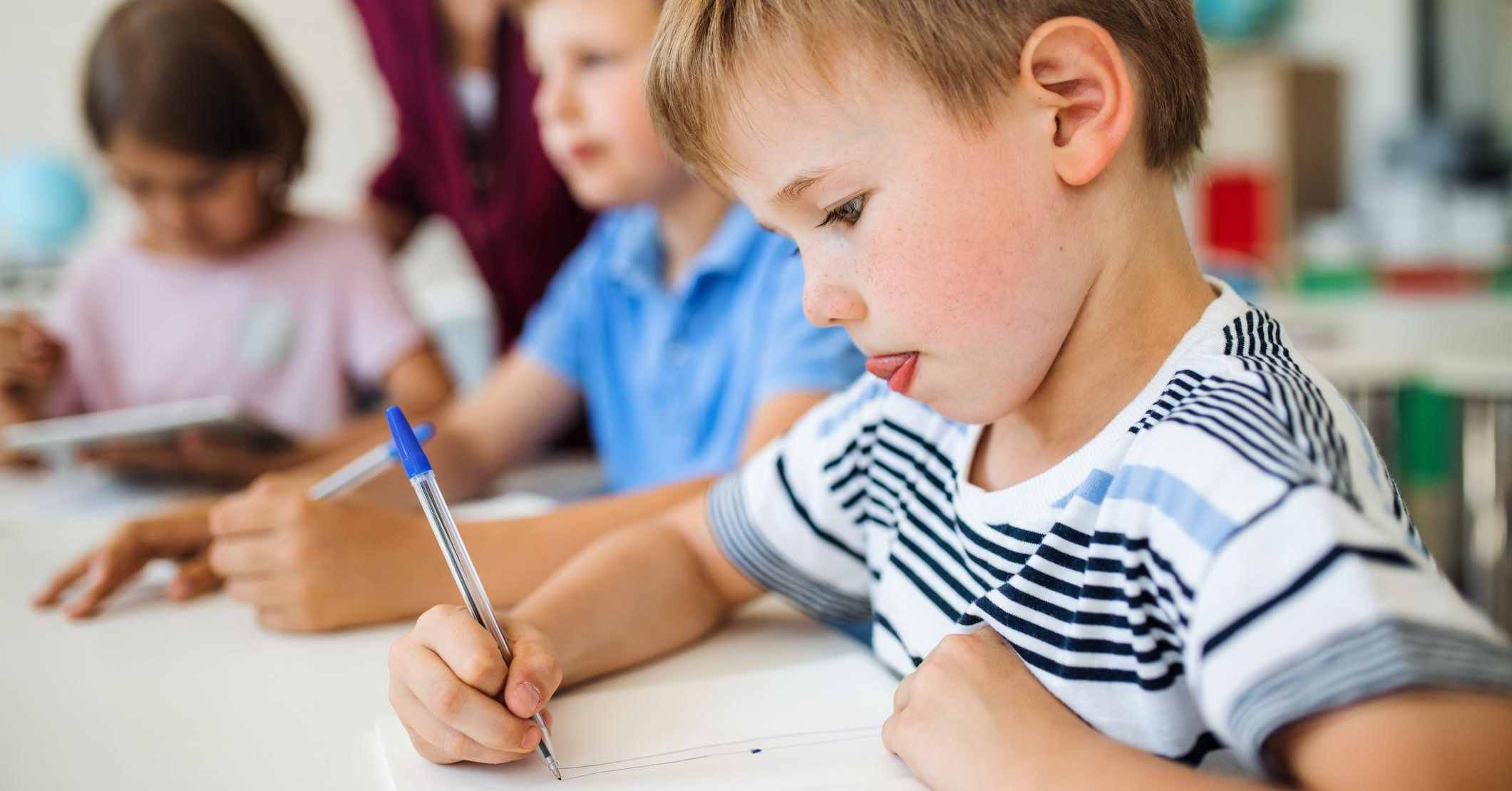 a group of young students working on a writing assignment