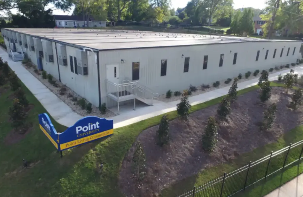 exterior of modular educational dorm rooms with gray siding and external steps to sidewalk
