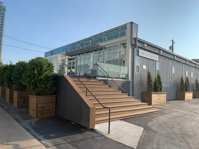 exterior of modular building with steps and railing planters boxes and shrubs