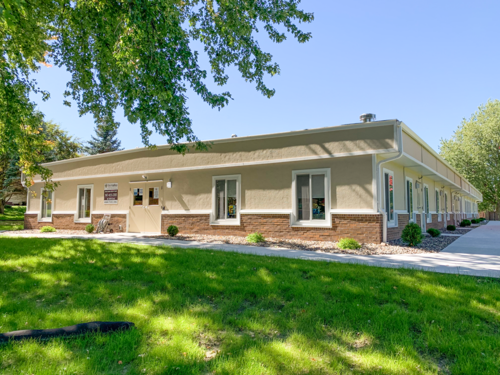 exterior of modular educational building with sidewalk and green grass