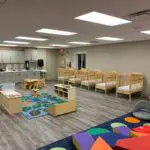 interior of modular educational building infant room with counters, cribs and playmat