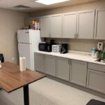 interior of modular educational building teacher lounge with counter table sink and refidgerator