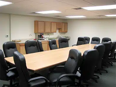 room with long table chair and kitchenette