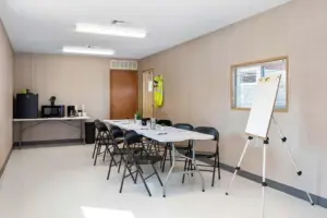 Side view of a mobile office set up with a table and chairs and a small kitchenette