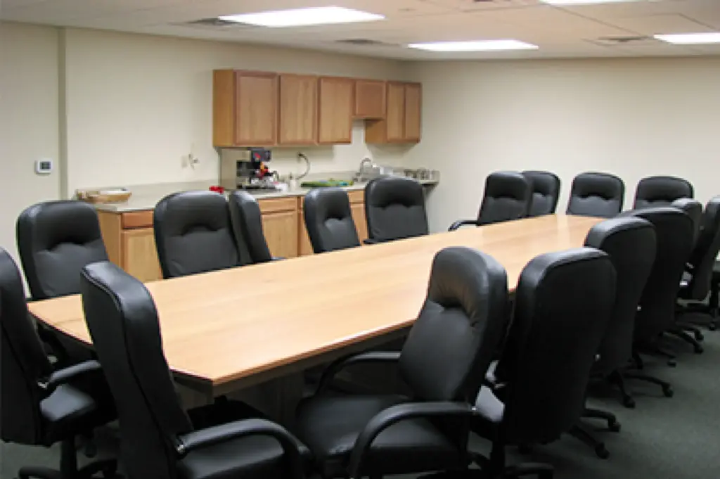 Conference room with a long wooden table and leather office chairs