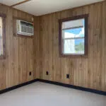 Mobile office interior with an air conditioning unit and wood paneling