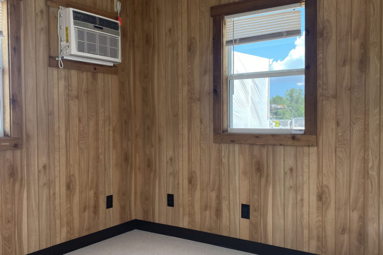 Mobile office interior with an air conditioning unit and wood paneling