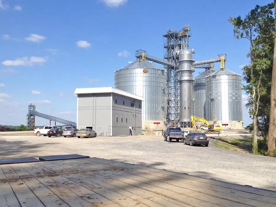 Multistory modular work building in front of grain silos.