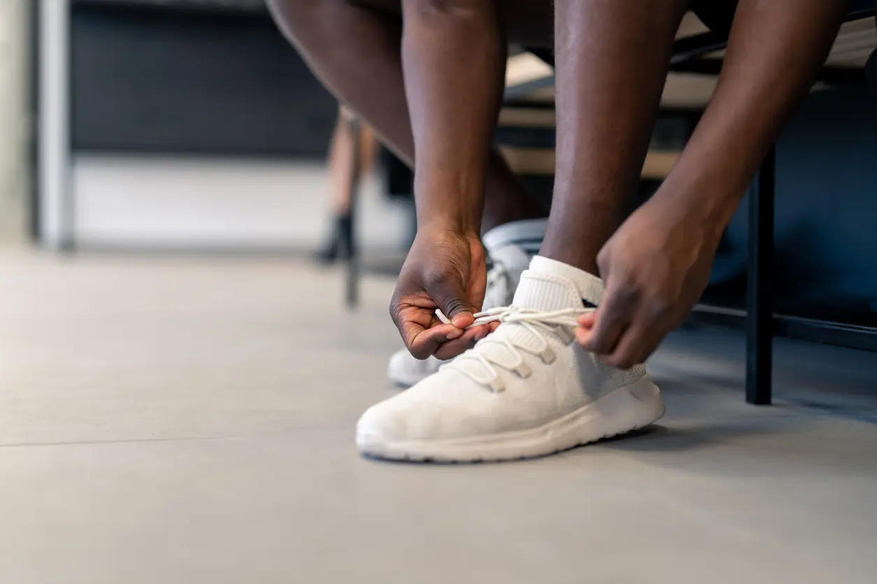 A student ties his shoe to prepare for gym class.