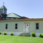 4-plex modular building located in front of a church building.