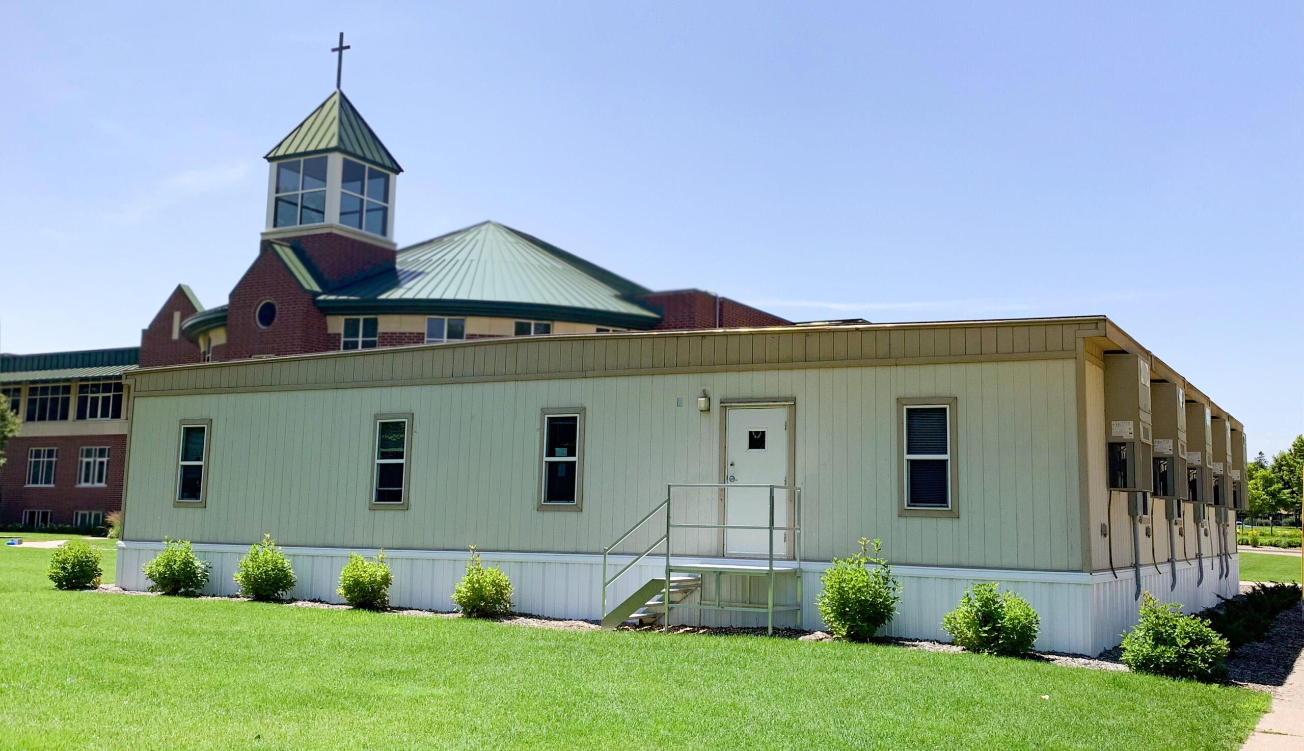 4-plex modular building located in front of a church building.