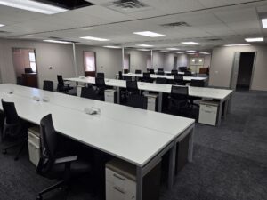 Interior meeting space of a custom modular building with long desks and chairs with filing cabinets