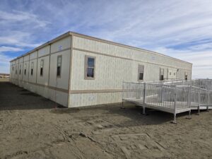 Exterior side view of 8-plex modular building with ADA ramp leading to exterior door