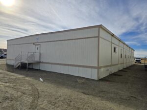 Exterior side view of modular building with stairs leading to single exterior door