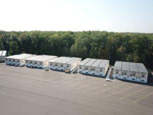 Aerial exterior overview of 5 4-plex modular buildings with ADA ramps and HVAC units.