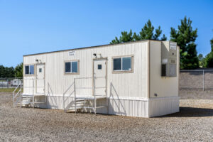 Exterior side view of a 10x40 mobile office with an HVAC unit attached to the end of the building
