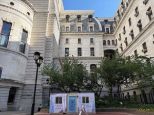 Exterior view of a Ground-level storage container sitting in front of a historic stone building.
