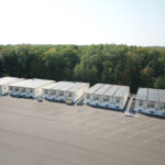 A row of mobile offices on a concrete lot.