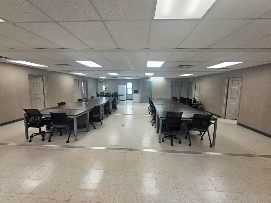 Large room with desks and office chairs.