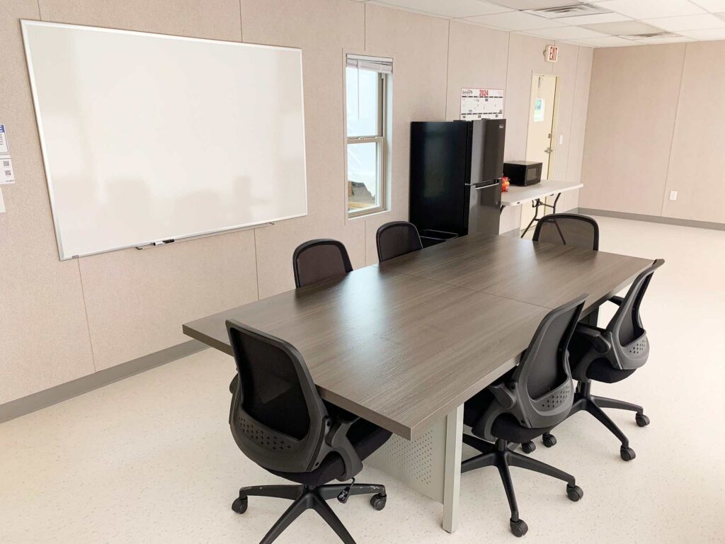 A conference table with office chairs around it.