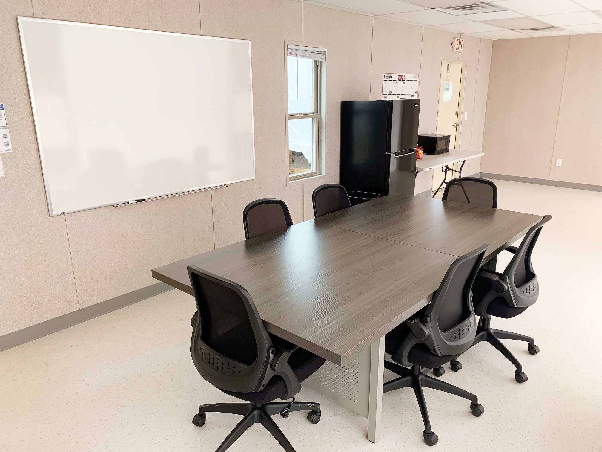 A conference table with office chairs around it.