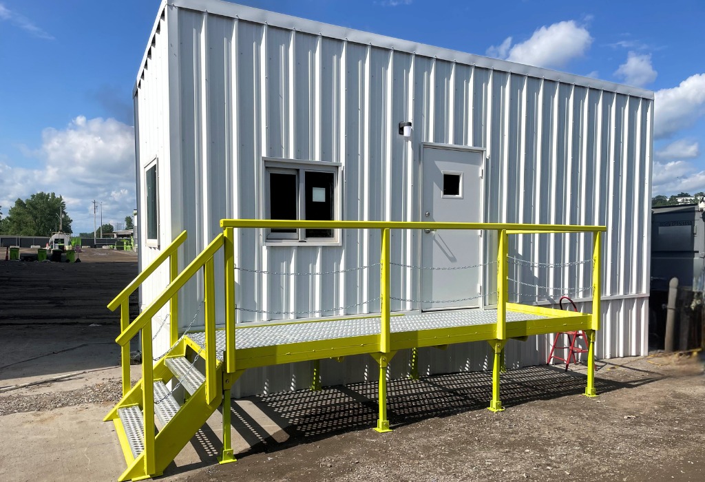 Custom 8×24 skidded office trailer installed next to the truck scale, giving operators a dedicated workspace without expanding the facility footprint.