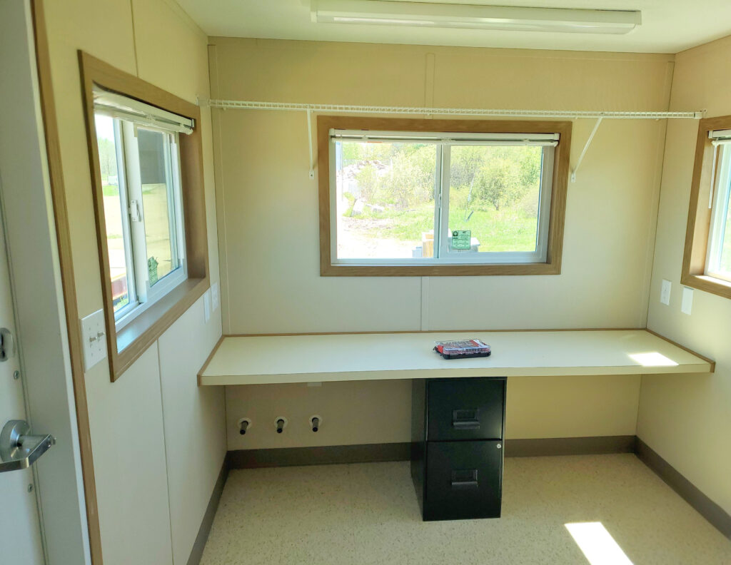 Office space inside the scale house with 360-degree visibility of yard operations through surrounding windows.
