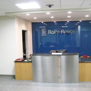two level reception desk with blue wall and Rolls Royce Logo