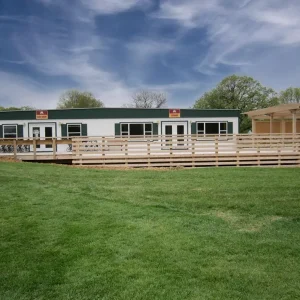 front view of green and white building with deck and railings